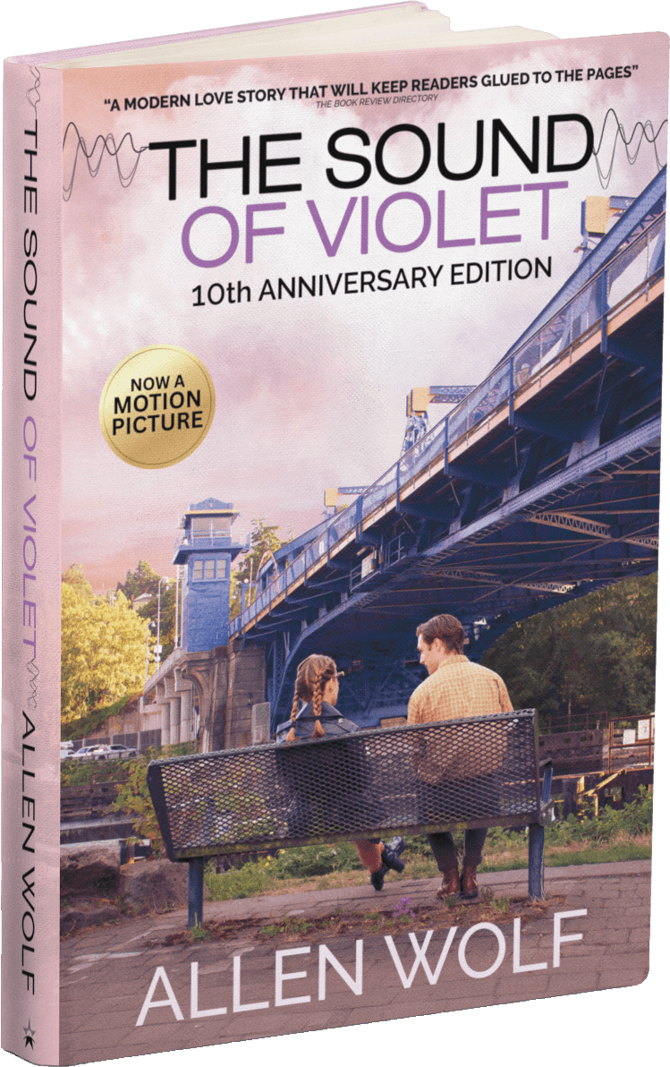 Two people sitting on a bench in front of a bridge.